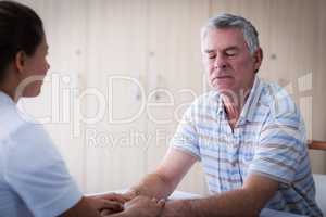 Female doctor consoling senior man
