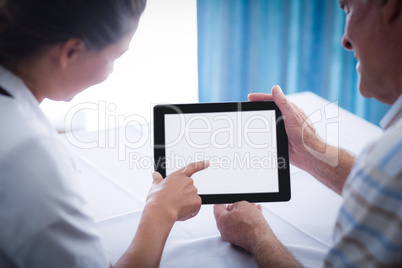 Senior man and female doctor using digital tablet