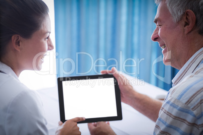 Senior man and female doctor using digital tablet