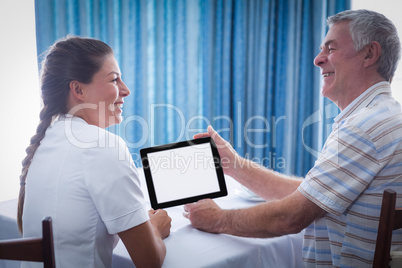 Senior man and female doctor using digital tablet