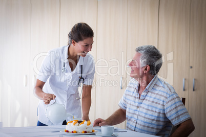 Female doctor celebration seniors man birthday in living room