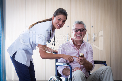 Portrait of female doctor giving medicine to senior man