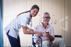 Portrait of female doctor giving medicine to senior man