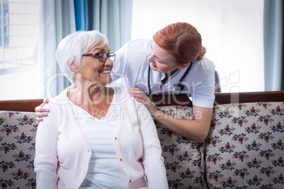 Smiling doctor talking to a happy senior woman