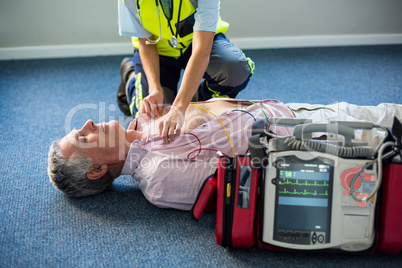 Paramedic using an external defibrillator on an unconscious patient