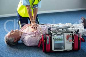 Paramedic using an external defibrillator during cardiopulmonary resuscitation