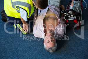 Paramedic using an external defibrillator during cardiopulmonary resuscitation