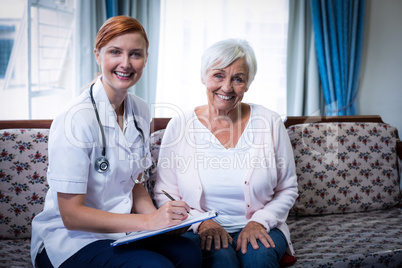 Smiling doctor consulting with senior woman