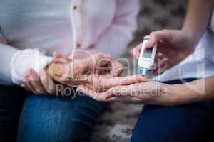 Doctor testing a patients glucose level using a digital glucometer