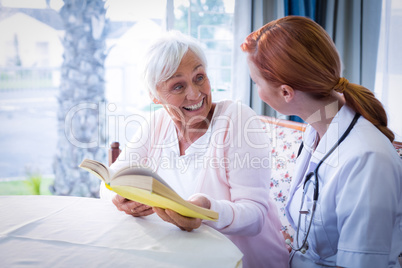 Happy doctor and patient reading a book