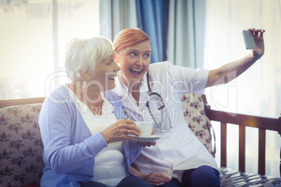 Smiling doctor and patient taking a selfie