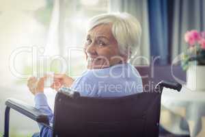 Happy senior woman on wheelchair holding a cup of tea