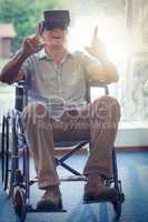 Happy senior man on wheelchair using VR headset
