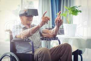 Happy senior man on wheelchair using VR headset