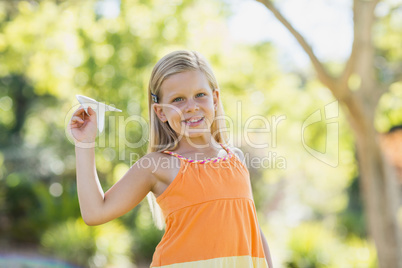 Young girl with a paper plane in park