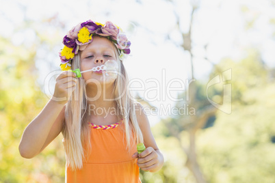 Young girl blowing bubbles through bubble wand