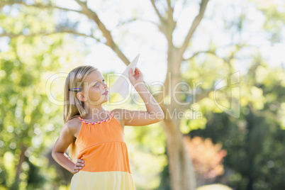 Young girl playing with a paper plane