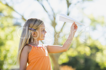 Young girl playing with a paper plane