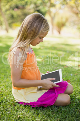 Young girl using digital tablet in park