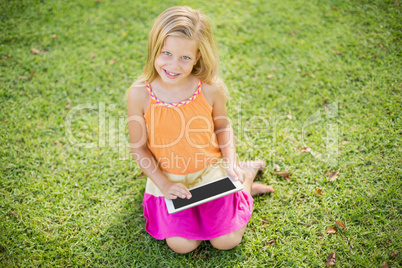 Young girl using digital tablet in park