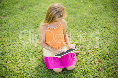 Young girl using digital tablet in park