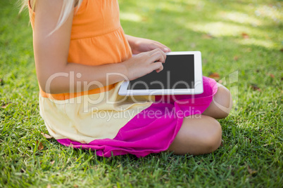 Young girl using digital tablet in park