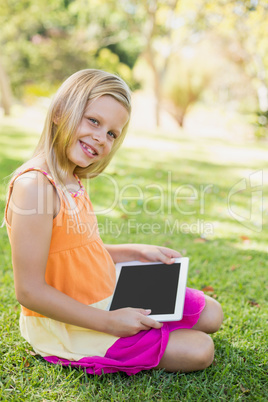 Young girl using digital tablet in park