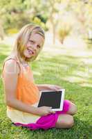Young girl using digital tablet in park