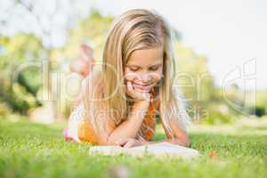 Young girl reading book in park