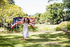 Young girl running with American flag