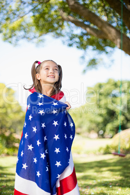 Young girl wrapped in American flag