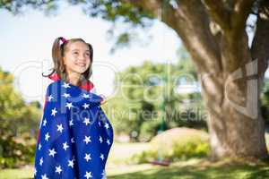 Young girl wrapped in American flag