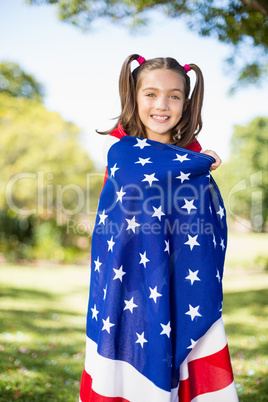 Young girl wrapped in American flag