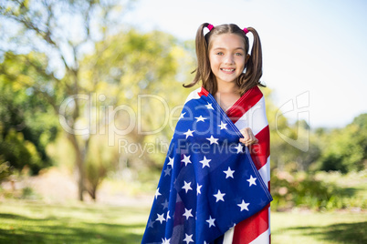 Young girl wrapped in American flag