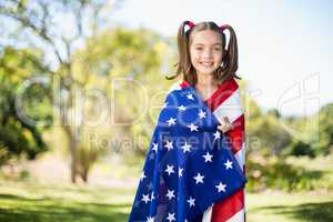 Young girl wrapped in American flag