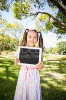 Young girl holding digital tablet in park
