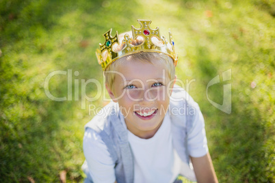 Young boy wearing a crown and smiling in park