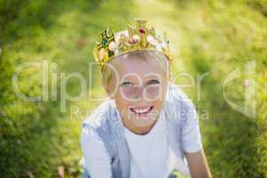 Young boy wearing a crown and smiling in park