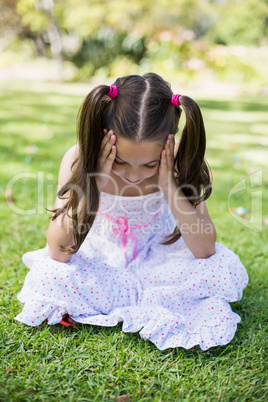 Upset girl sitting with hand on forehead