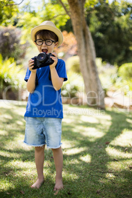 Young boy in spectacles holding a camera