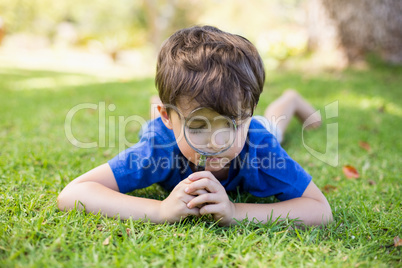 Boy examining grass with a magnifying glass