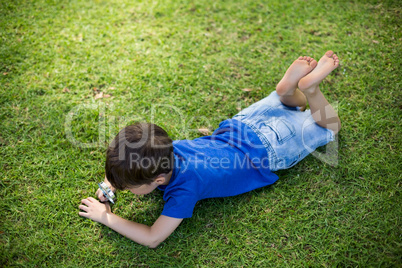 Boy examining grass with a magnifying glass