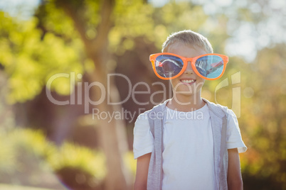 Young boy with giant sunglasses smiling at camera
