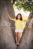 Young girl standing on tree trunk