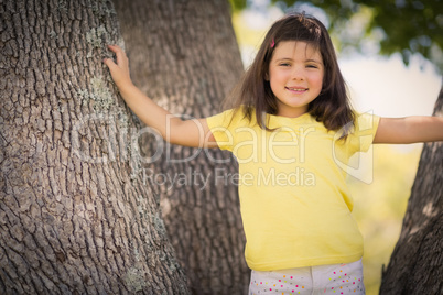 Young girl standing on tree trunk