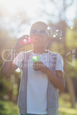 Young boy blowing bubbles through bubble wand