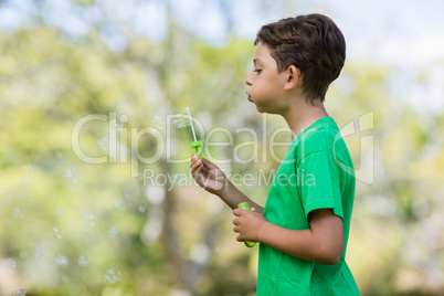 Young boy blowing bubbles through bubble wand