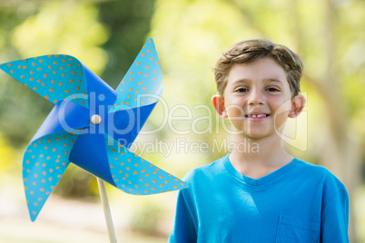 Boy holding a pinwheel in park