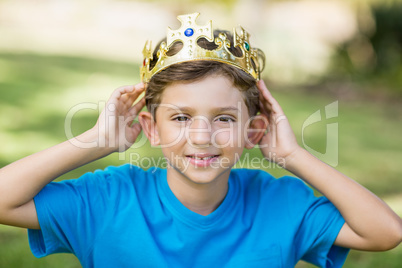 Young boy wearing a crown in park