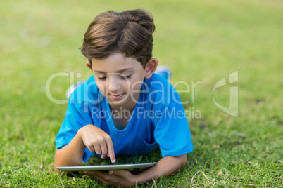 Young boy using digital tablet in park